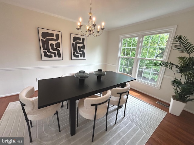 dining room with baseboards, a chandelier, wood finished floors, and visible vents
