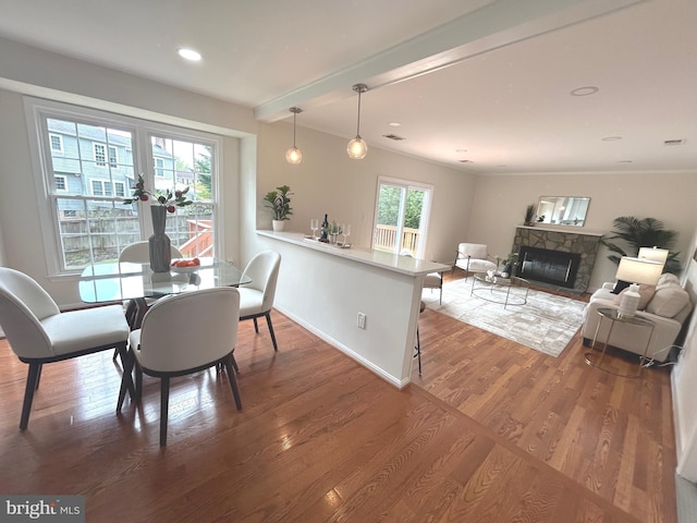 dining space featuring baseboards, a fireplace, recessed lighting, and wood finished floors