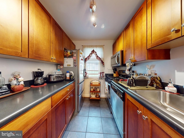 4408 1st Pl NE Unit 14, Washington, DC 20011 - kitchen with stainless steel appliances, brown cabinets, tile patterned flooring, dark countertops, and a sink