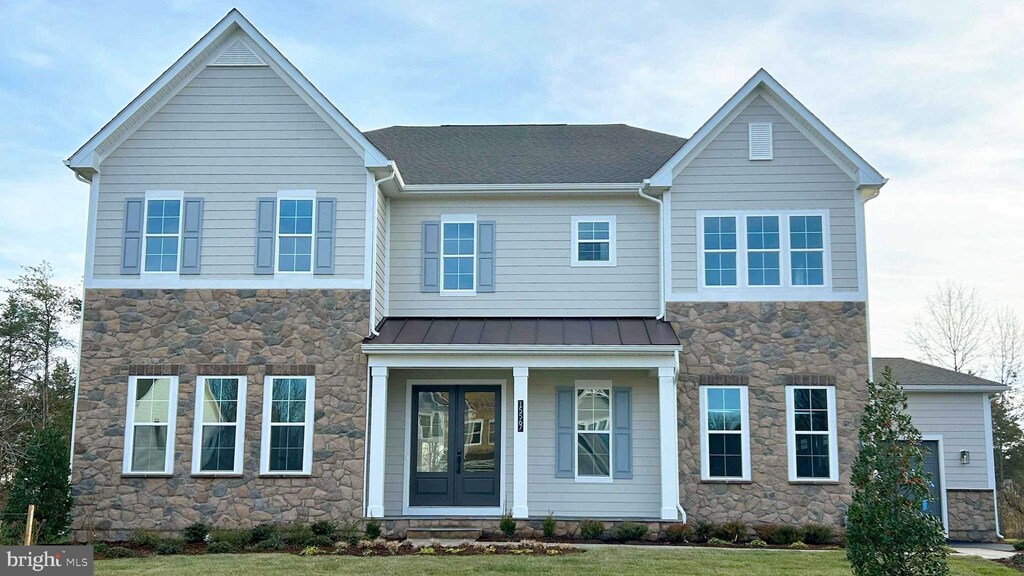 15595 Cloverland Ln, Haymarket, VA 20169 - view of front facade featuring covered porch, a standing seam roof, metal roof, a front lawn, and stone siding