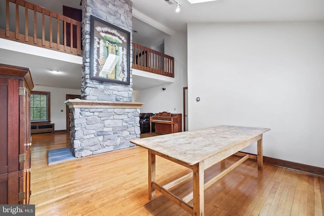 1218 Lower Ferry Rd, Ewing, NJ 08618 - dining area with hardwood / wood-style floors, high vaulted ceiling, baseboards, and a stone fireplace