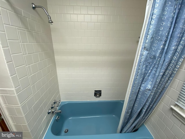 full bathroom with tile walls and shower / tub combo
