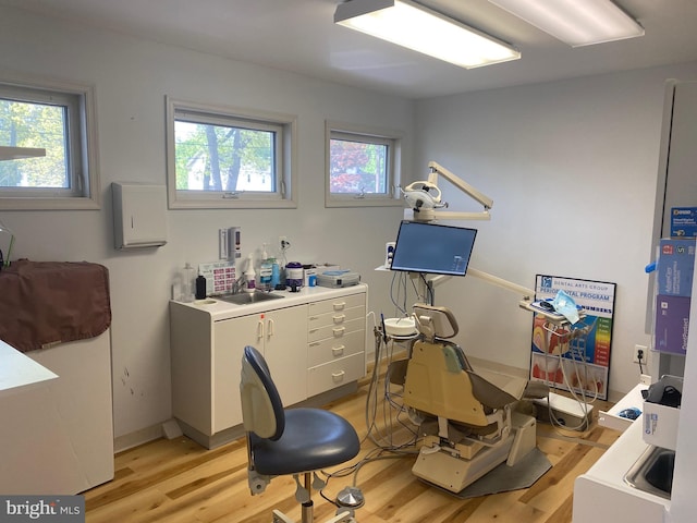 office space with a sink, a healthy amount of sunlight, and light wood-style floors
