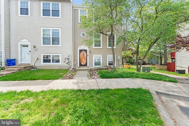 townhome / multi-family property with a front lawn