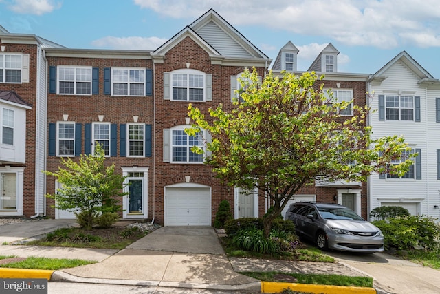 townhome / multi-family property featuring concrete driveway, an attached garage, and brick siding