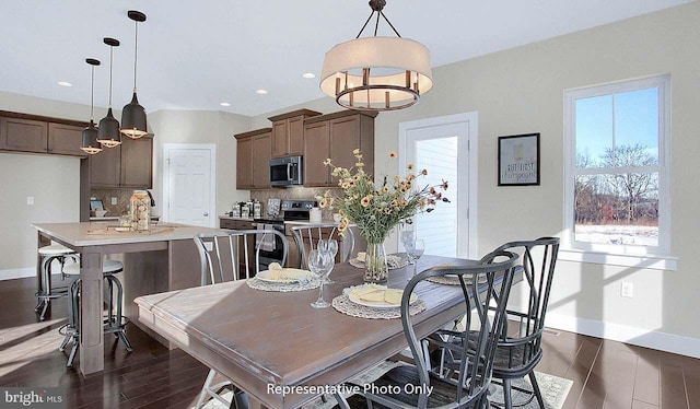 dining area featuring baseboards, a chandelier, a wealth of natural light, and dark wood-type flooring