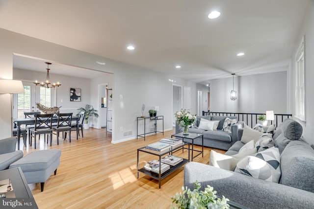 living room featuring recessed lighting, a chandelier, light wood finished floors, and visible vents