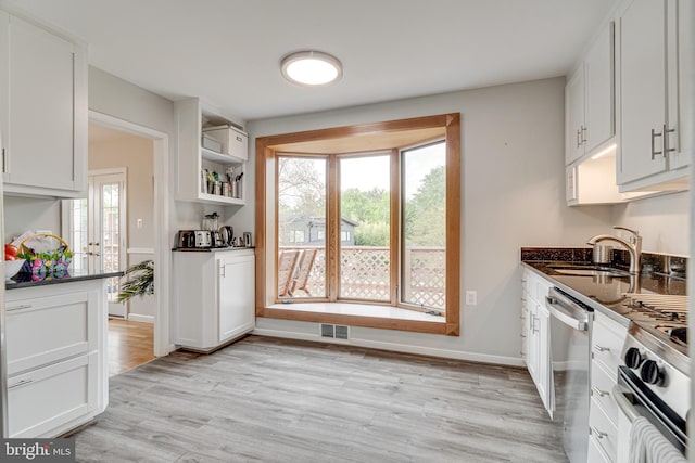 kitchen with visible vents, appliances with stainless steel finishes, light wood-type flooring, a sink, and white cabinetry