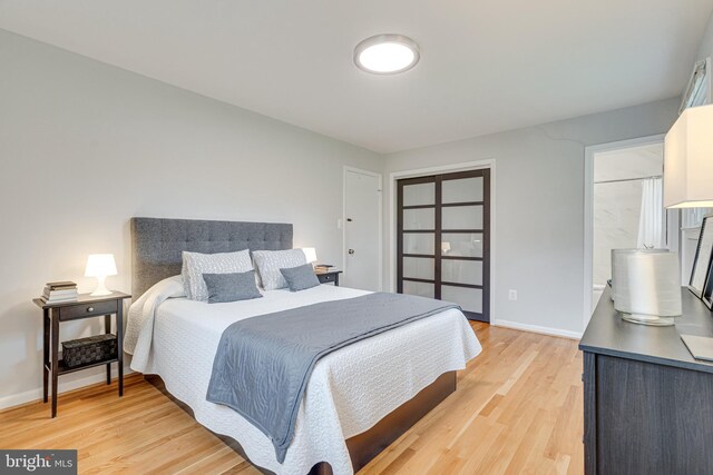 bedroom featuring light wood-type flooring, baseboards, and a closet