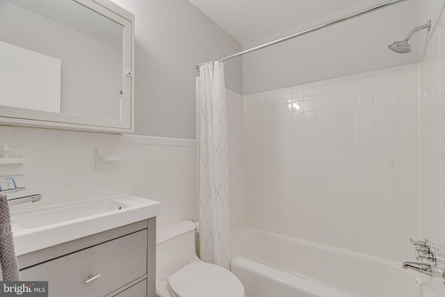 bathroom featuring tile walls, vanity, toilet, and shower / bath combination with curtain