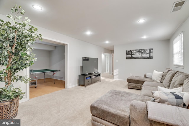living area featuring light colored carpet, visible vents, and recessed lighting