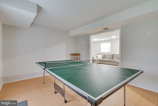 rec room with baseboards, visible vents, and wood finished floors