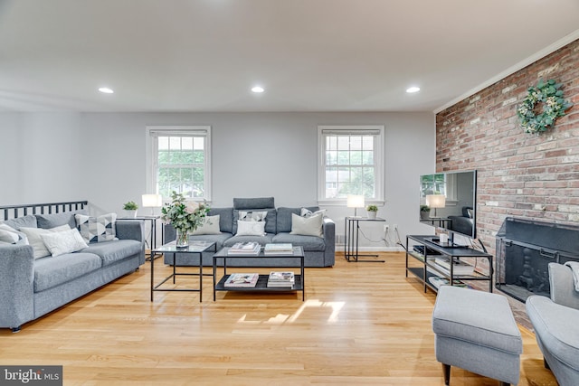 living area featuring a brick fireplace, recessed lighting, and wood finished floors