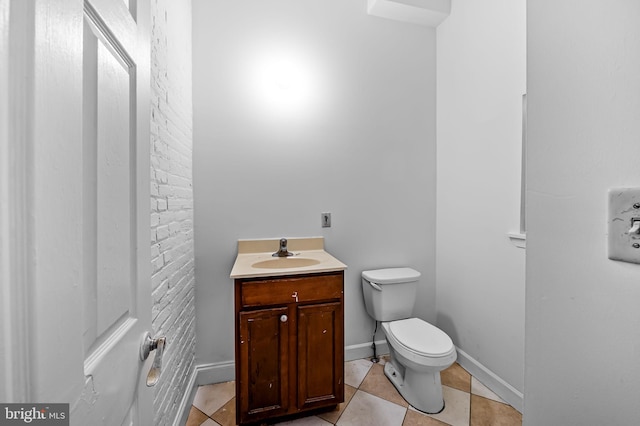 bathroom with toilet, vanity, and tile patterned floors