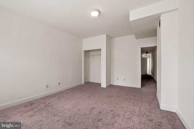 unfurnished bedroom featuring carpet, baseboards, and a closet