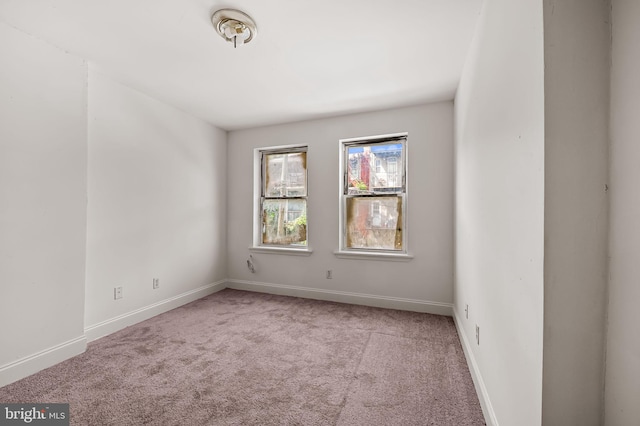 carpeted spare room featuring baseboards
