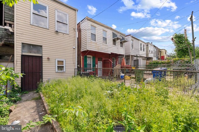 rear view of house featuring fence
