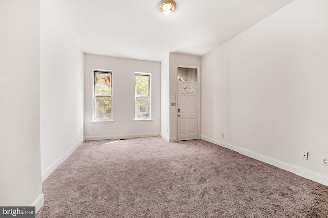 unfurnished room with carpet floors and baseboards