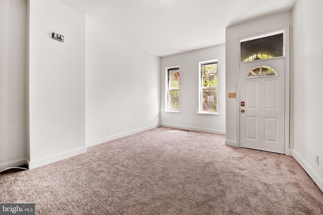 foyer featuring carpet flooring and baseboards