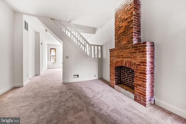 unfurnished living room with carpet flooring, baseboards, a fireplace, and stairway