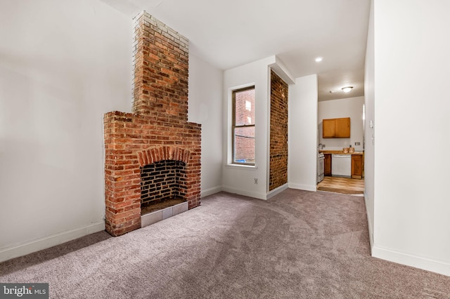 unfurnished living room with light colored carpet, baseboards, and a fireplace