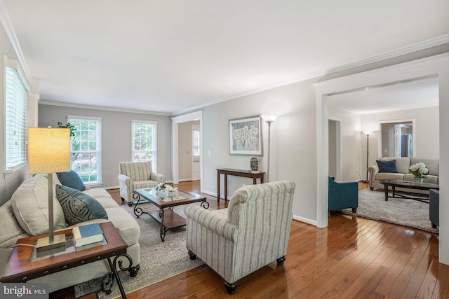 living area with baseboards, ornamental molding, and hardwood / wood-style floors