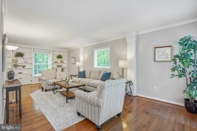 living area with crown molding, baseboards, built in features, and wood finished floors