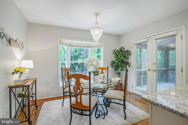 dining space with baseboards, plenty of natural light, and wood finished floors