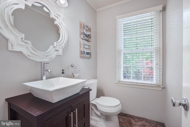 bathroom featuring crown molding, baseboards, vanity, and toilet