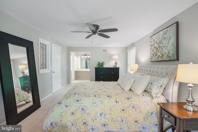 bedroom with carpet flooring, baseboards, visible vents, and connected bathroom