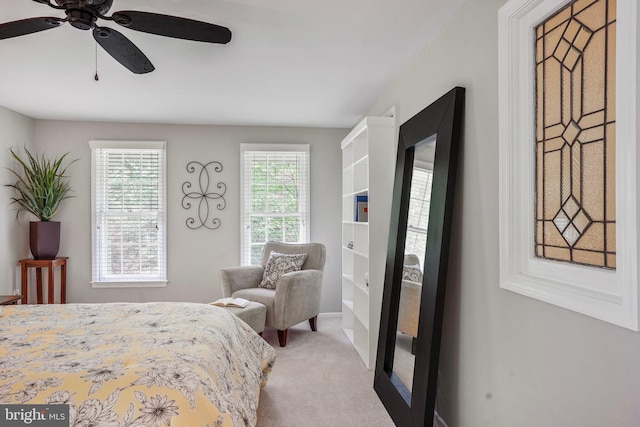 bedroom featuring light carpet and a ceiling fan