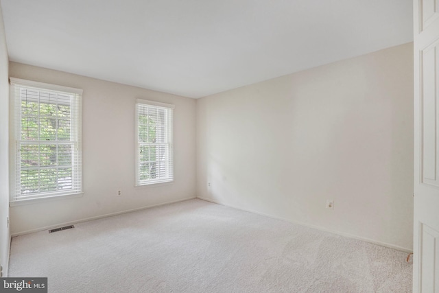 unfurnished room with baseboards, visible vents, and carpet