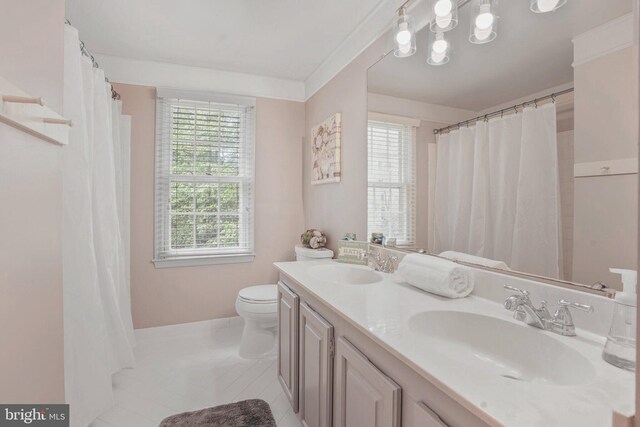 bathroom featuring double vanity, toilet, tile patterned floors, and a sink