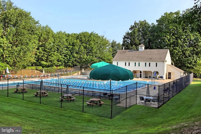 pool featuring a lawn and fence