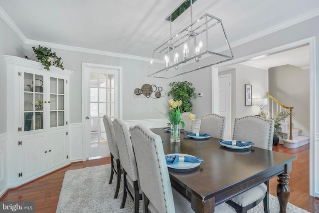 dining space featuring crown molding, wood finished floors, and a notable chandelier