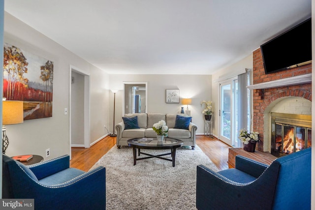 living room with baseboards, wood finished floors, and a fireplace