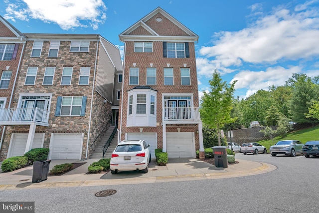 townhome / multi-family property with an attached garage, brick siding, and concrete driveway