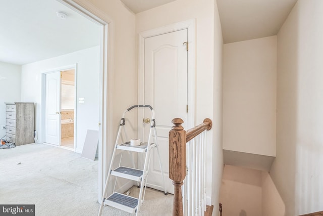 hall with an upstairs landing and carpet