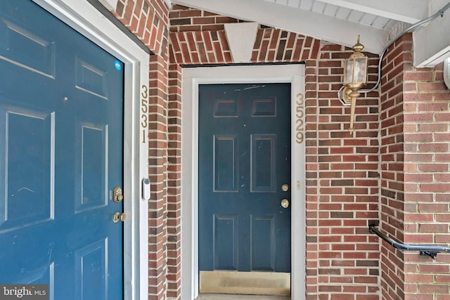 view of exterior entry featuring brick siding