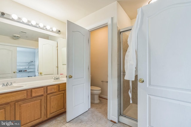 full bathroom with toilet, a shower stall, a sink, and tile patterned flooring
