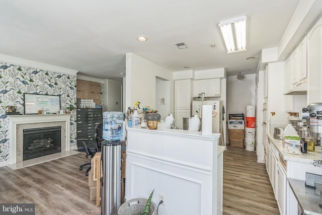 kitchen featuring light wood-style floors, light countertops, under cabinet range hood, and white cabinets