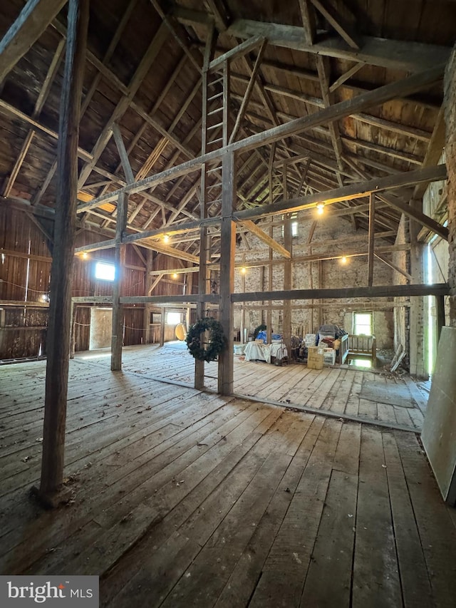 miscellaneous room with high vaulted ceiling and hardwood / wood-style flooring