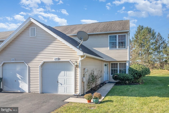 view of front of home with a shingled roof, an attached garage, driveway, and a front yard