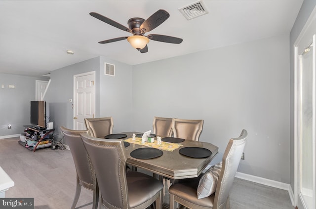dining space featuring light wood-style floors, baseboards, a ceiling fan, and visible vents