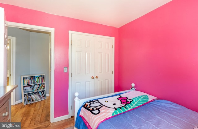 bedroom featuring a closet, baseboards, and light wood-style floors