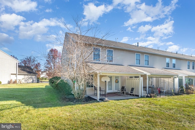 rear view of property with a lawn, a patio area, and fence