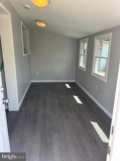 empty room with baseboards and wood finished floors