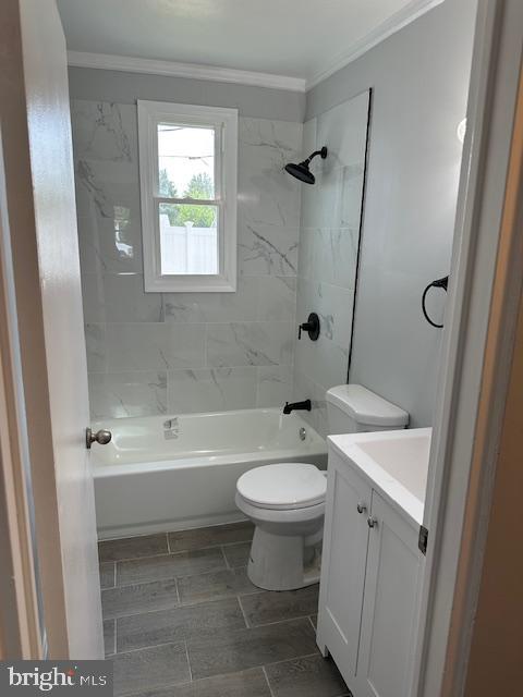 bathroom with vanity, shower / tub combination, crown molding, and toilet