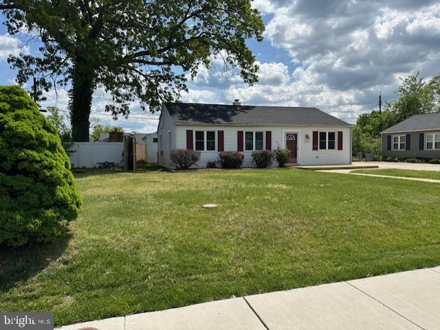 ranch-style home with fence and a front lawn