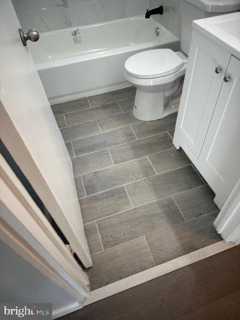 bathroom with vanity, a washtub, walk in shower, and toilet